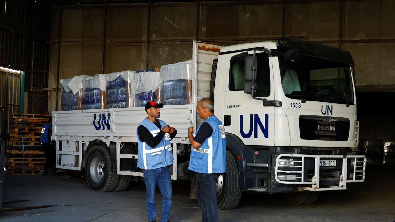 Workers sort aid to be distributed to Palestinians, at a United Nations-run facility, in Khan Younis