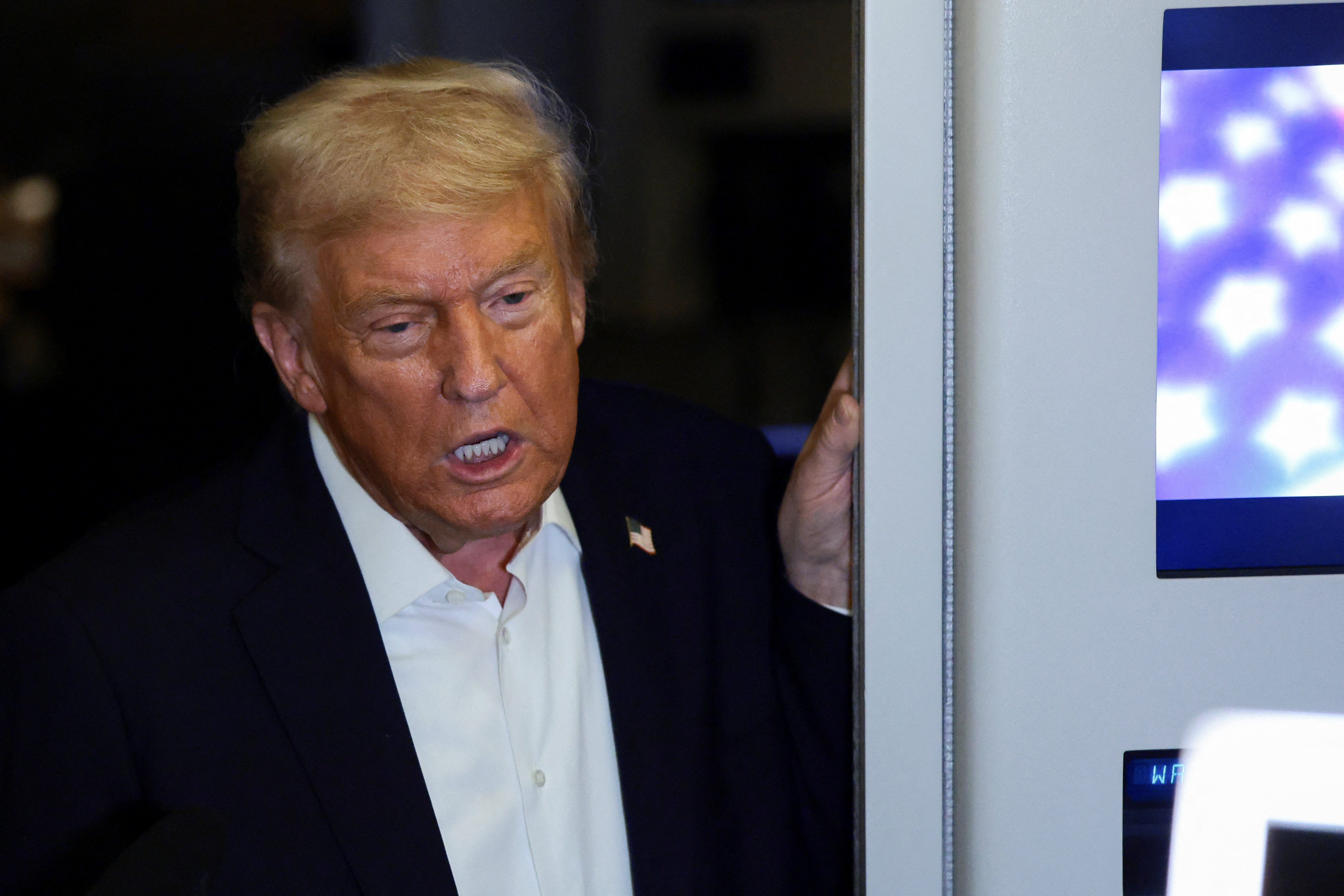 U.S. President Donald Trump speaks to the media aboard Air Force One