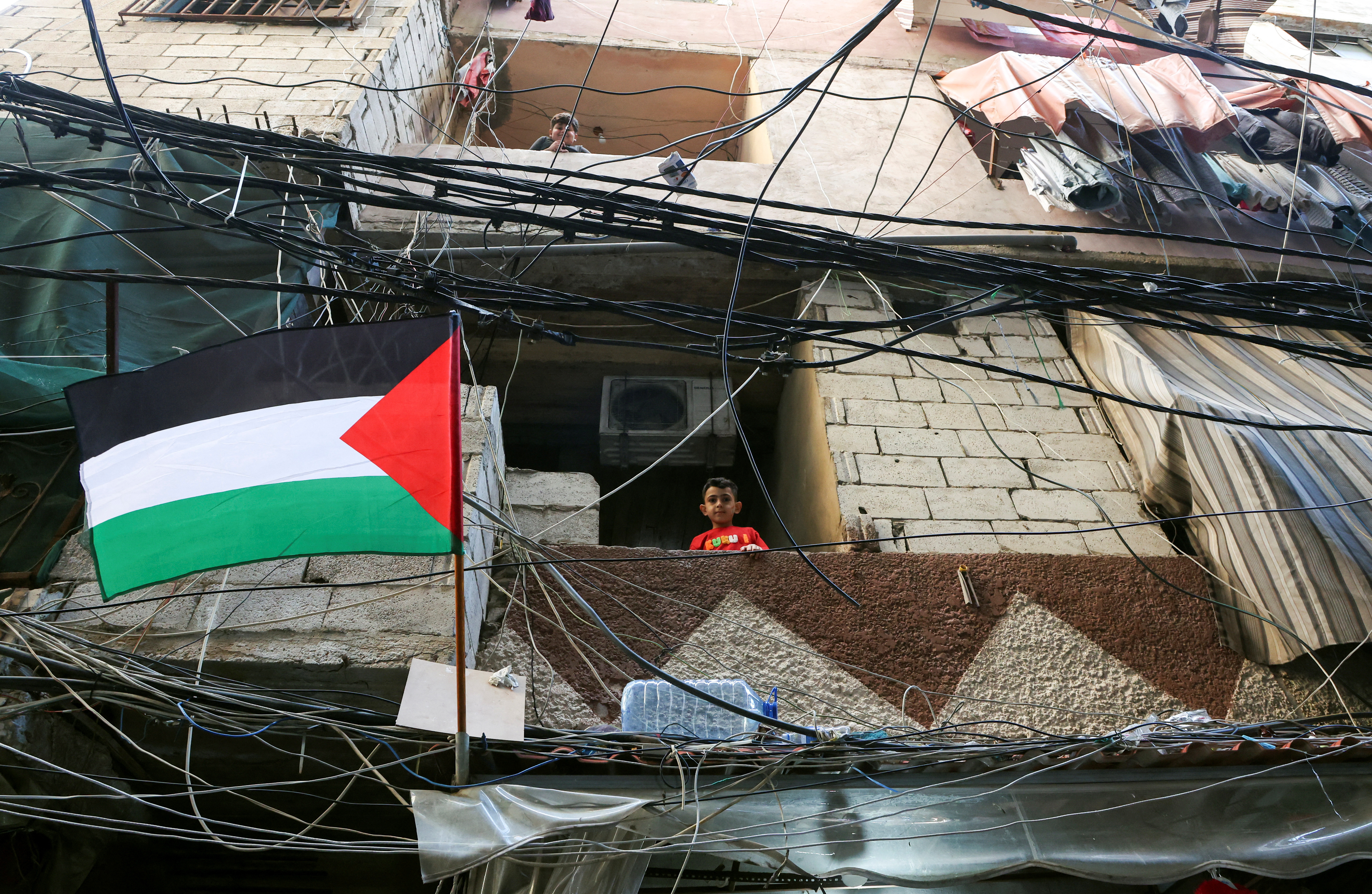 Children look out from balconies in Shatila Palestinian refugee camp, in Beirut