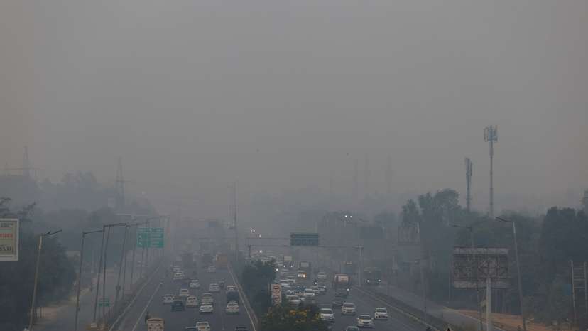 Vehicles ride past on an expressway on a smoggy morning in New Delhi