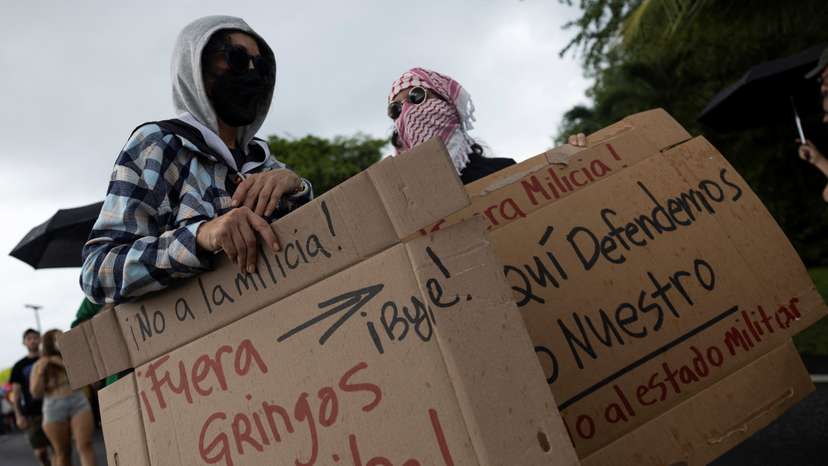 People rally against military exercises in front of the Muniz Puerto Rico Air National Guard Base, in Carolina