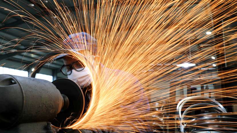 FILE PHOTO: Worker wearing a face mask works on a production line manufacturing bicycle steel rim at a factory in Hangzhou, Zhejiang