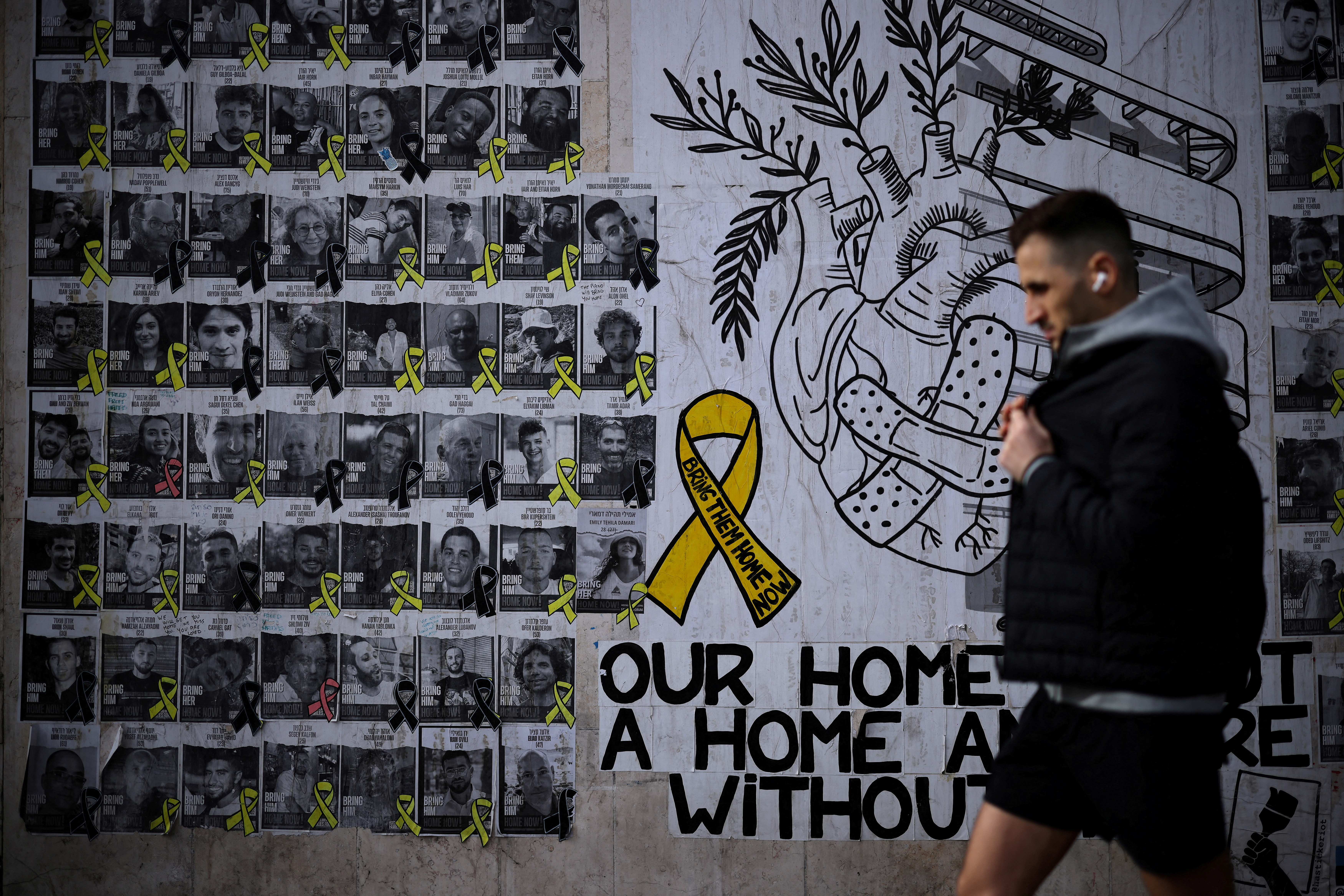 FILE PHOTO: Man walks past posters of hostages kidnapped during the deadly October 7 attack by Hamas, in Tel Aviv