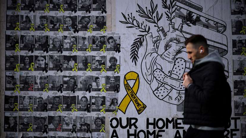 FILE PHOTO: Man walks past posters of hostages kidnapped during the deadly October 7 attack by Hamas, in Tel Aviv