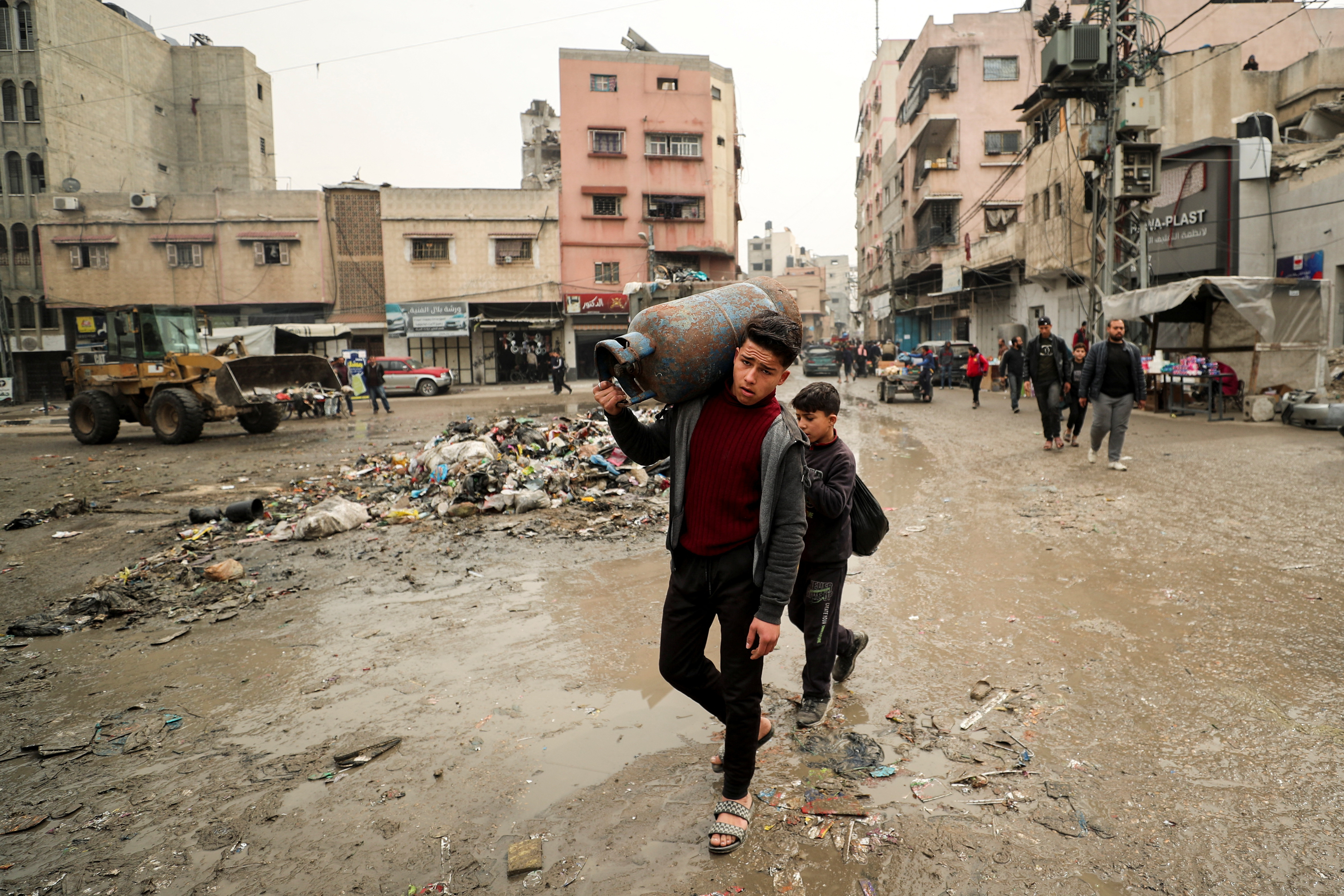 Palestinian carries a cooking gas cylinder, in Gaza City