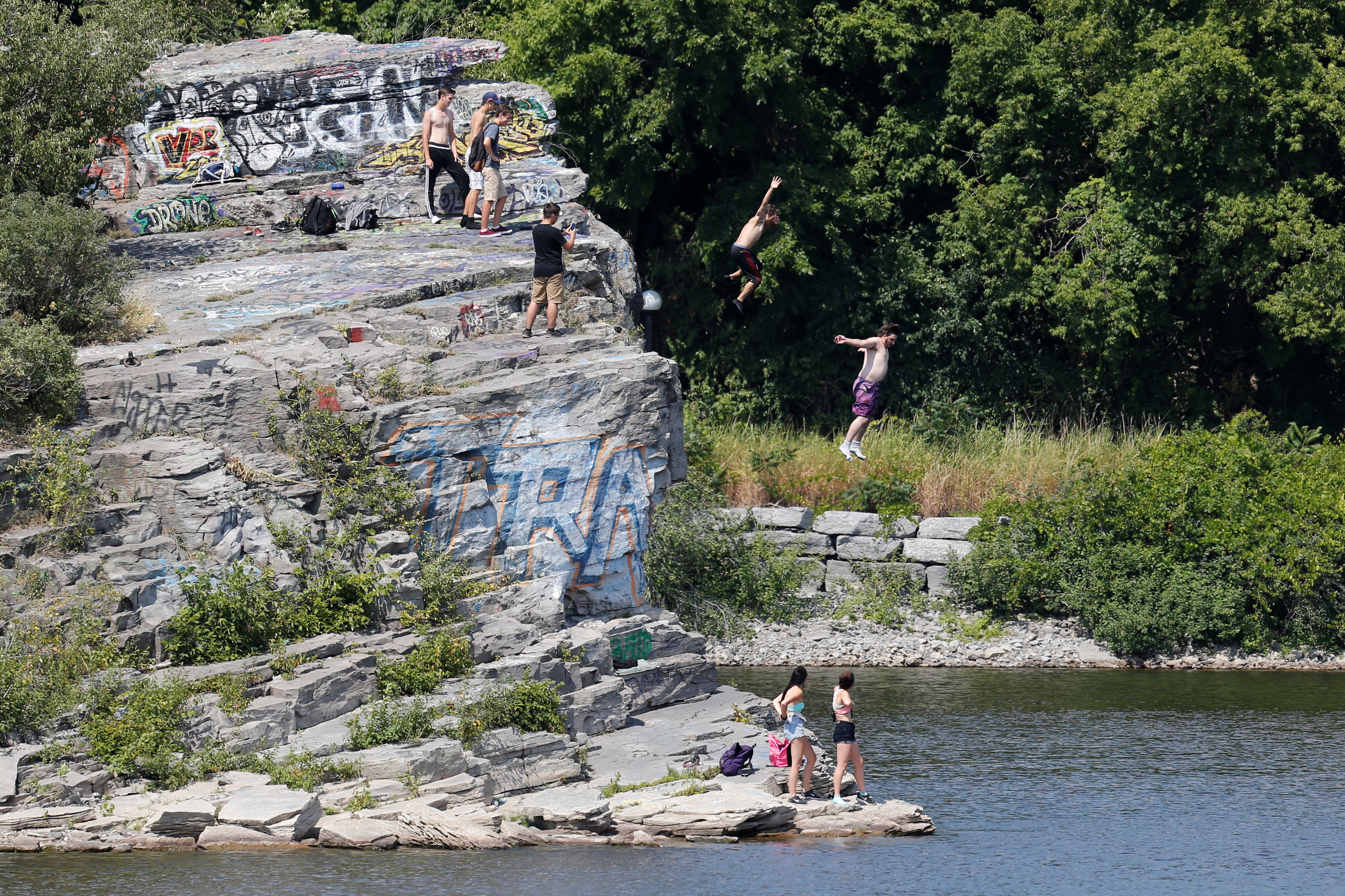 People jump into the Ottawa River on a hot summer day in Gatineau