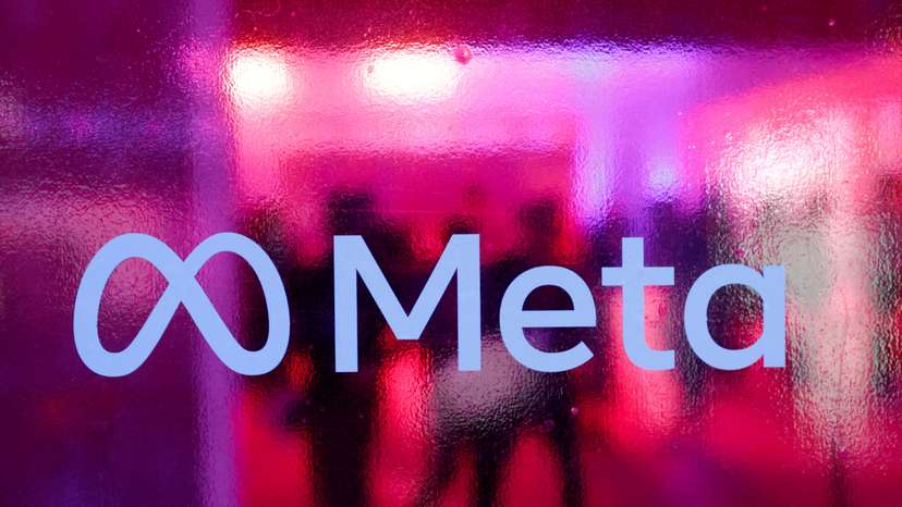 FILE PHOTO: People walk behind a Meta Platforms logo during a conference in Mumbai,