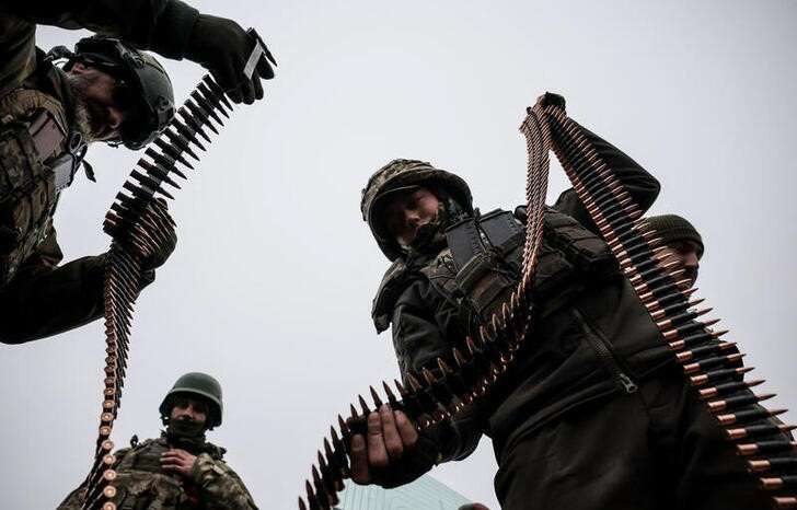 FILE PHOTO: Ukrainian servicemen load cartridges to a machine gun strip during an exercise in Donetsk region
