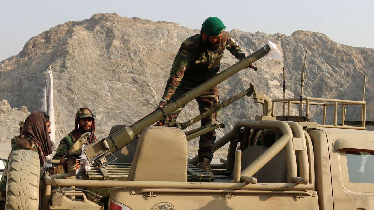 Taliban soldiers load a rocket launcher in a vehicle near Torkham border