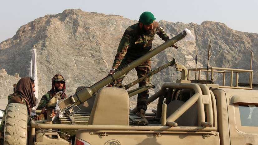 Taliban soldiers load a rocket launcher in a vehicle near Torkham border