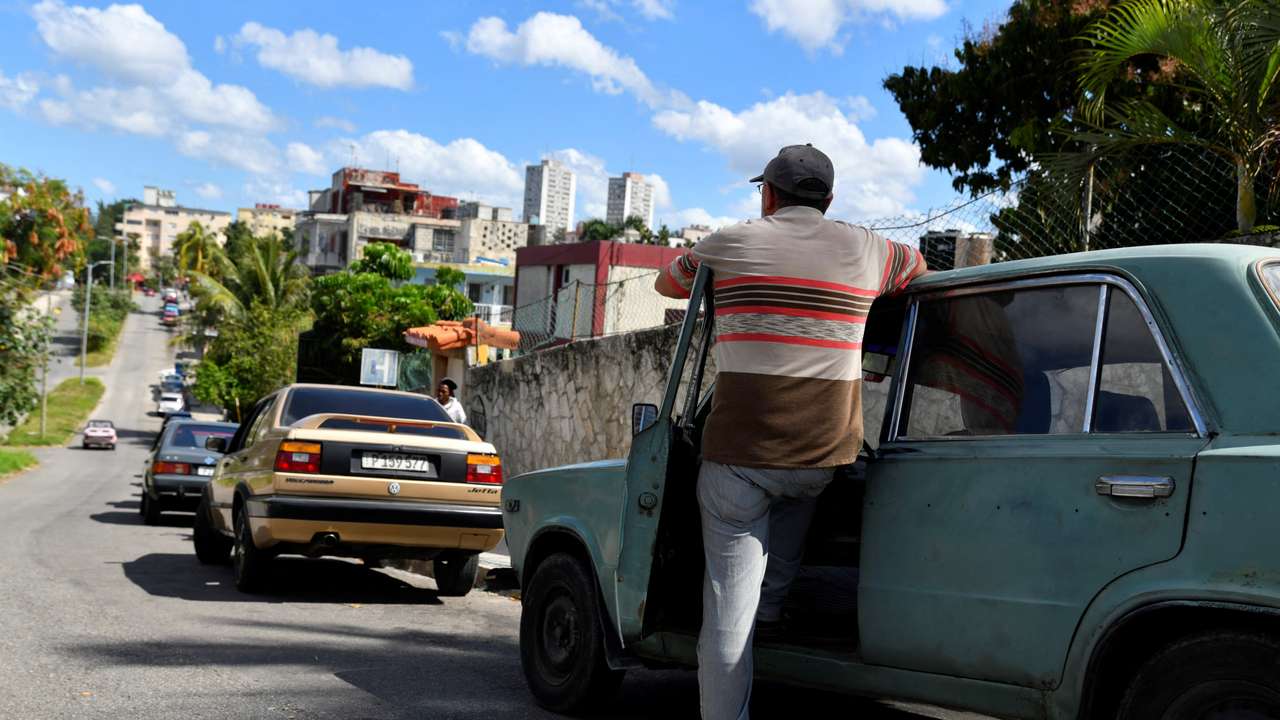 A man waits along other drivers to buy gasoline at a petrol station, in Havana