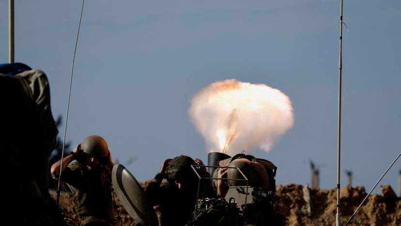 Israeli soldiers fire a mortar as the conflict continues between Israel and Hamas