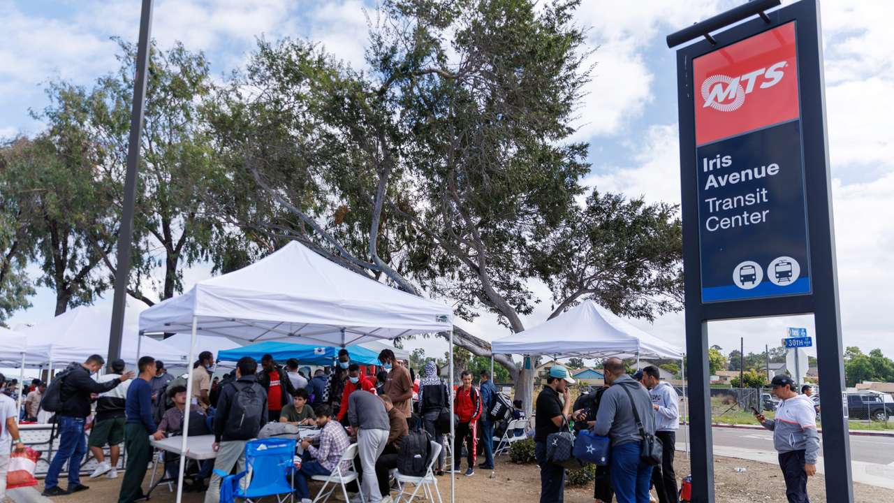 Migrants gather at transit center after crossing border