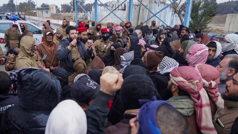 FILE PHOTO: A member of Syrian military police speaks to relatives of detainees of al-Aqtan prison, where Islamic State detainees are held, after the Syrian government took control of the facility, in Raqqa