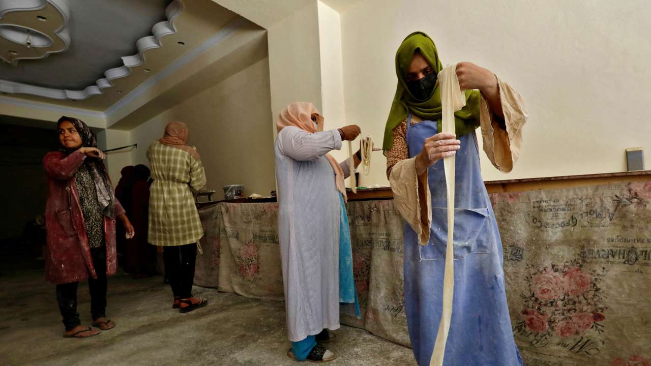 FILE PHOTO: Afghan women prepare dough to make traditional cookies inside a bakery, in Kabul