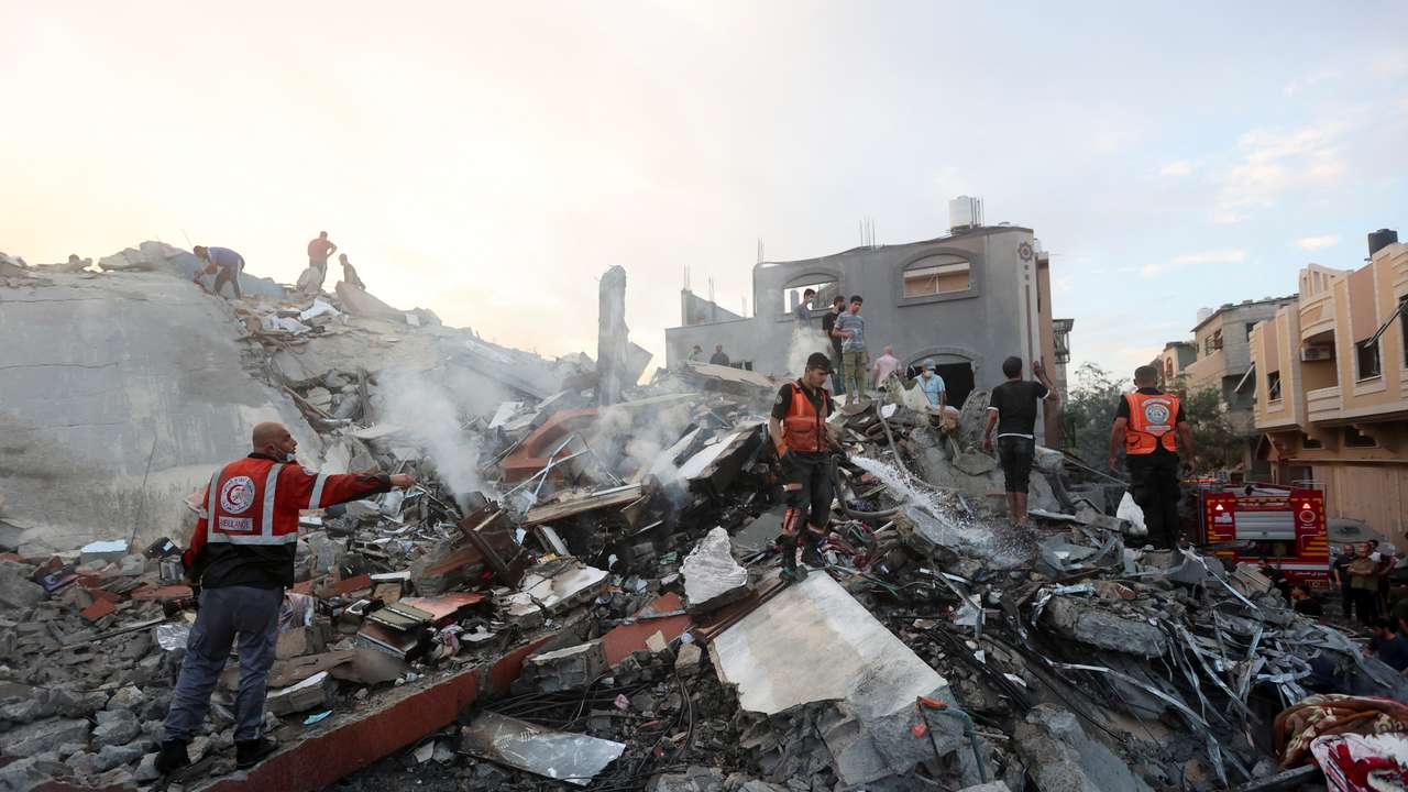 Palestinians search for casualties at the site of Israeli strikes on a residential building