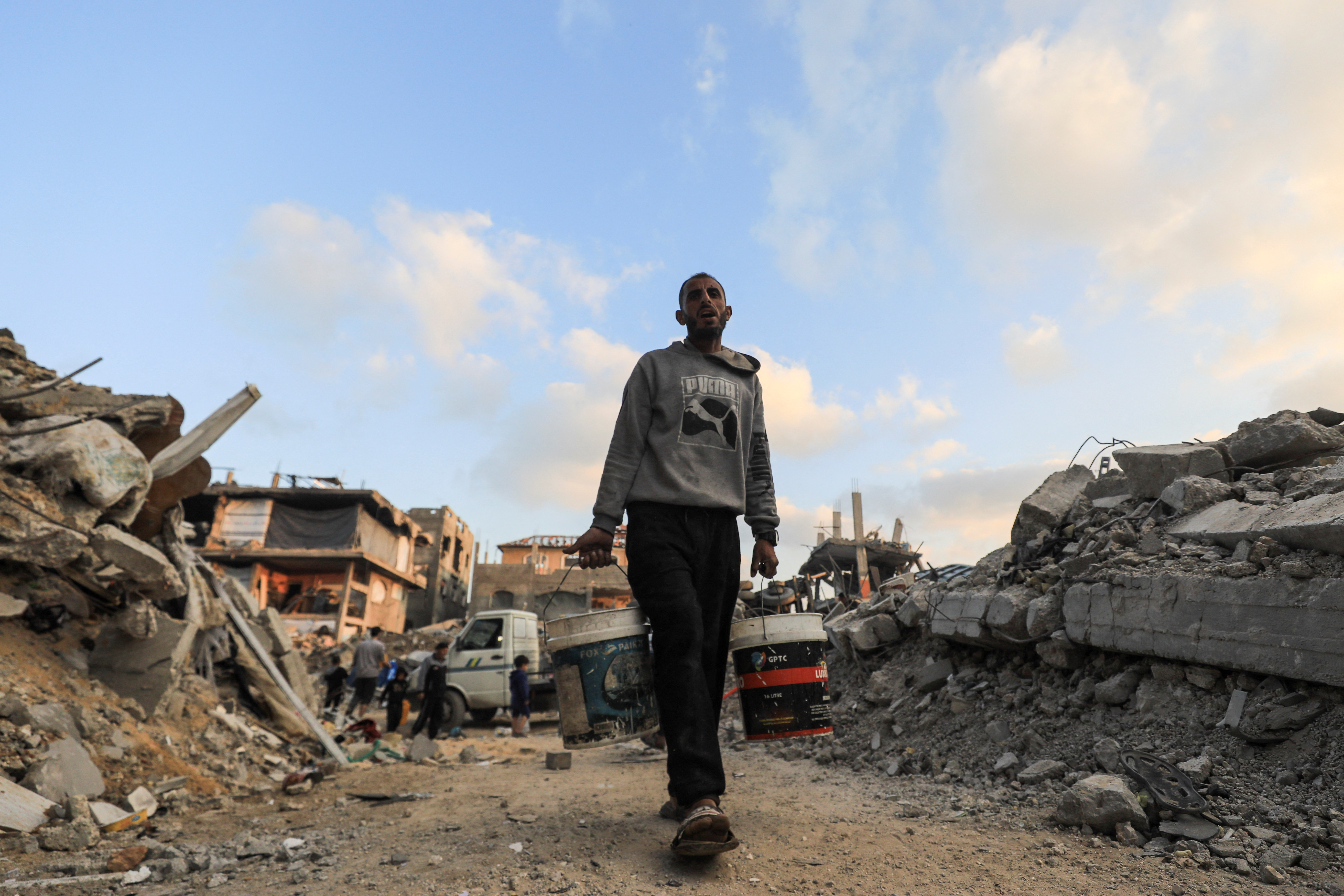 A Palestinian carries water, in Jabalia refugee camp