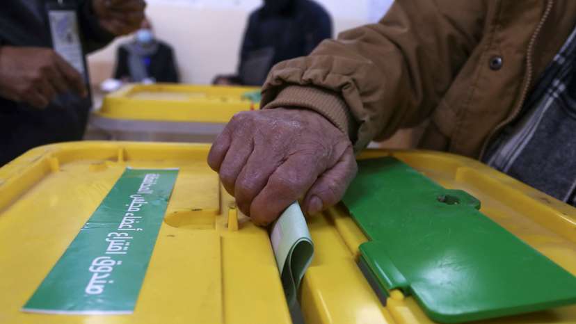 A voter casts a ballot to vote in the municipal and local governorate councils elections in Amman