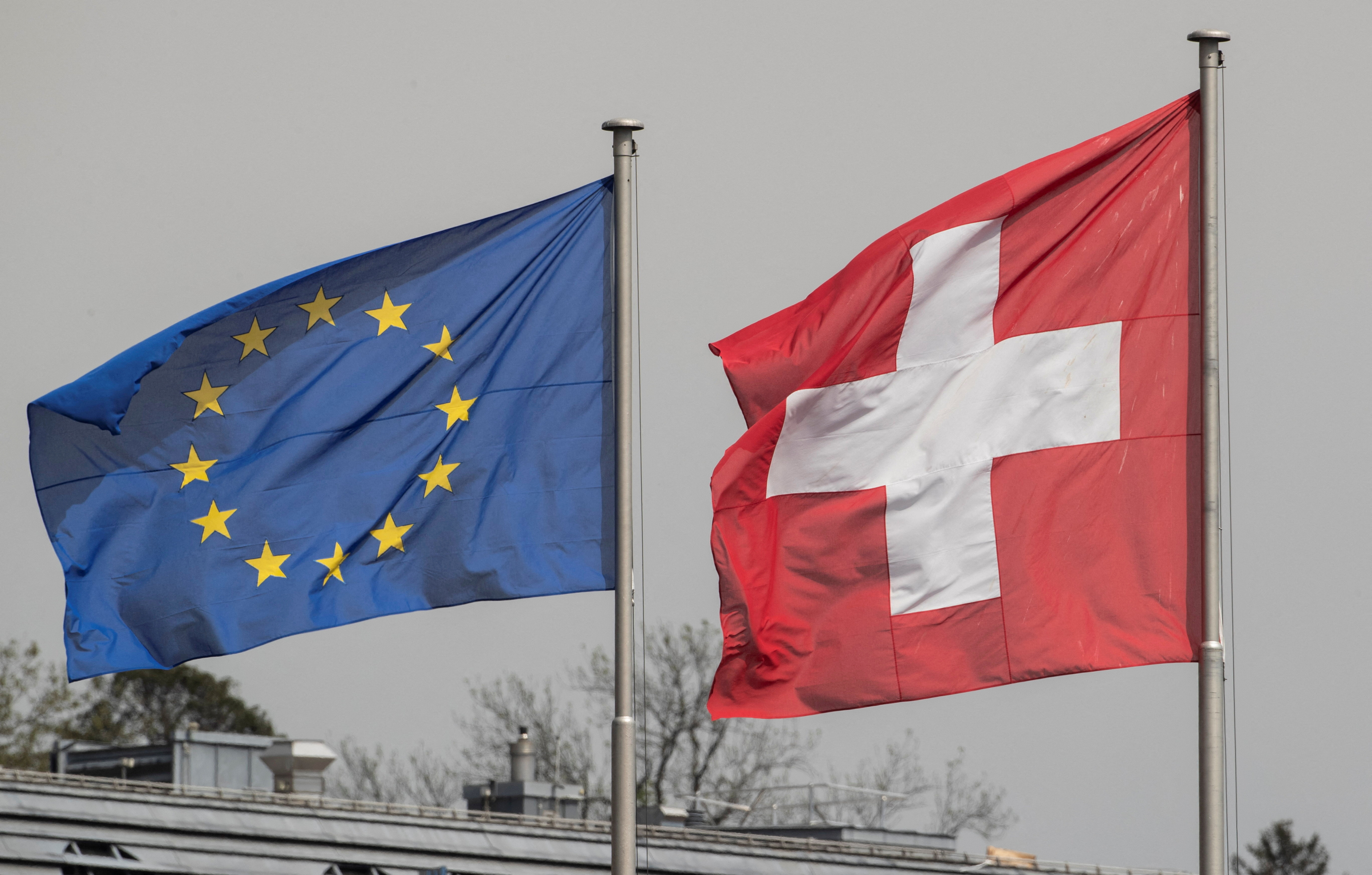 FILE PHOTO: Switzerland's national flag flies beside the one of the European Union in Zurich
