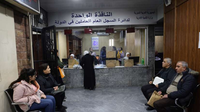 People wait at a government building in Damascus
