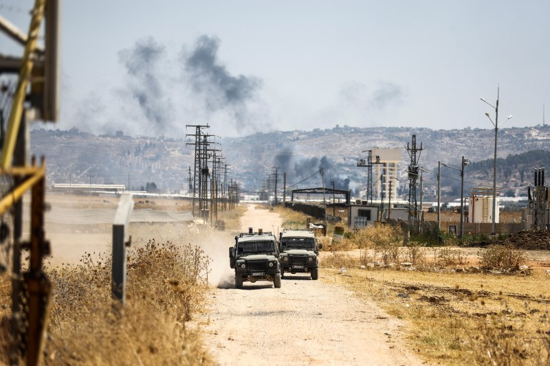 FILE PHOTO: Israeli military jeeps drive on a road leading from a raid on Jenin refugee camp, as seen from Salem checkpoint