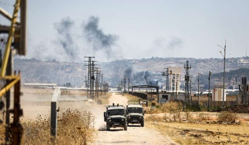 FILE PHOTO: Israeli military jeeps drive on a road leading from a raid on Jenin refugee camp, as seen from Salem checkpoint