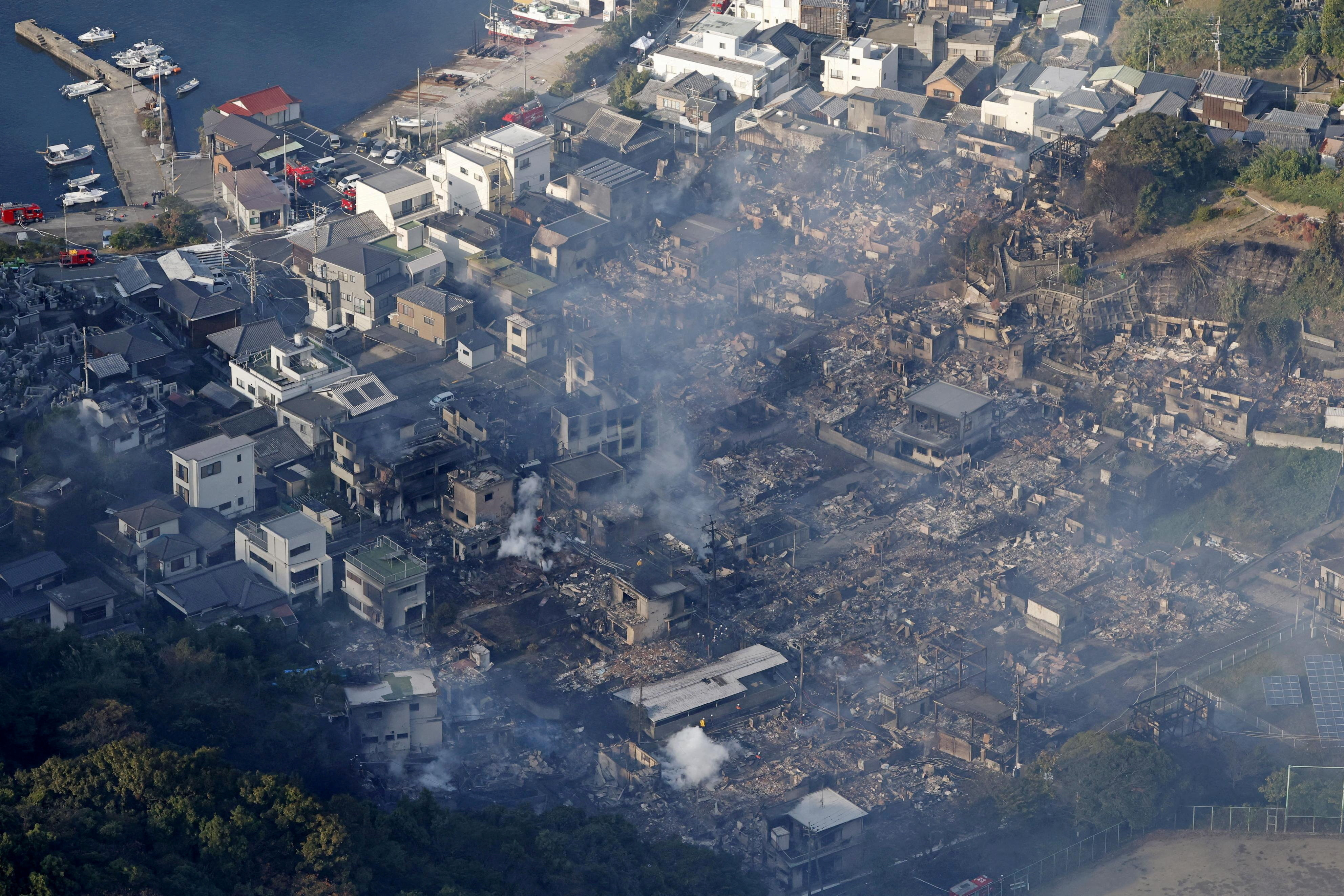 Smoke rises from a site where a massive fire blazed through more than 170 buildings, as seen from a helicopter, in Oita