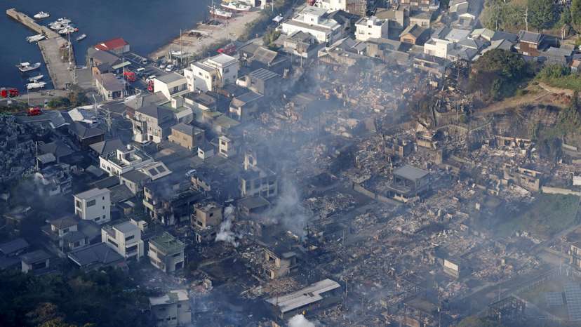 Smoke rises from a site where a massive fire blazed through more than 170 buildings, as seen from a helicopter, in Oita