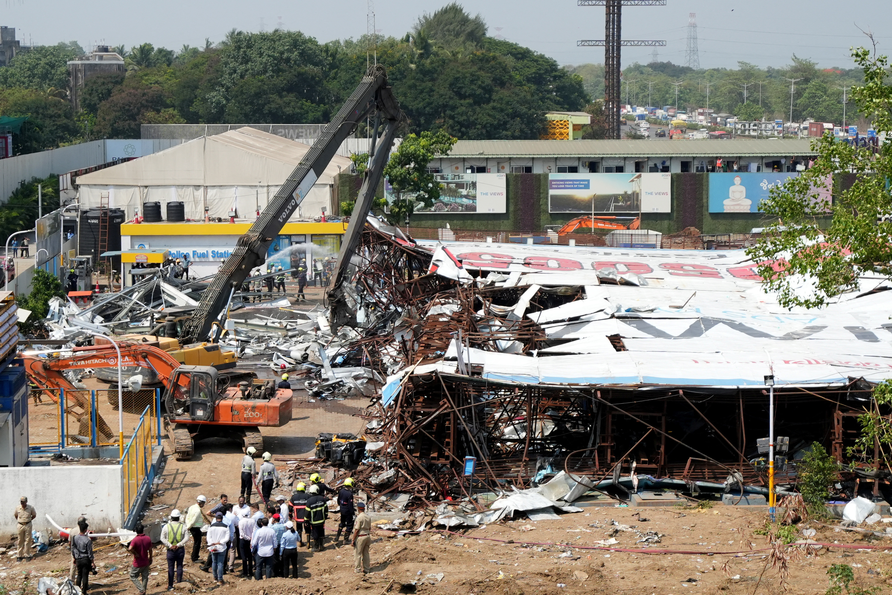 A machine is used to clear the debris at a fuel station after a massive billboard fell during a rainstorm in Mumbai