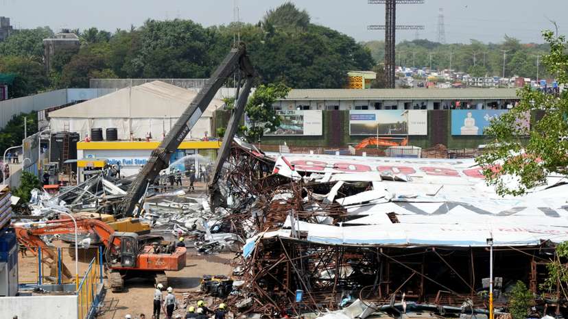 A machine is used to clear the debris at a fuel station after a massive billboard fell during a rainstorm in Mumbai