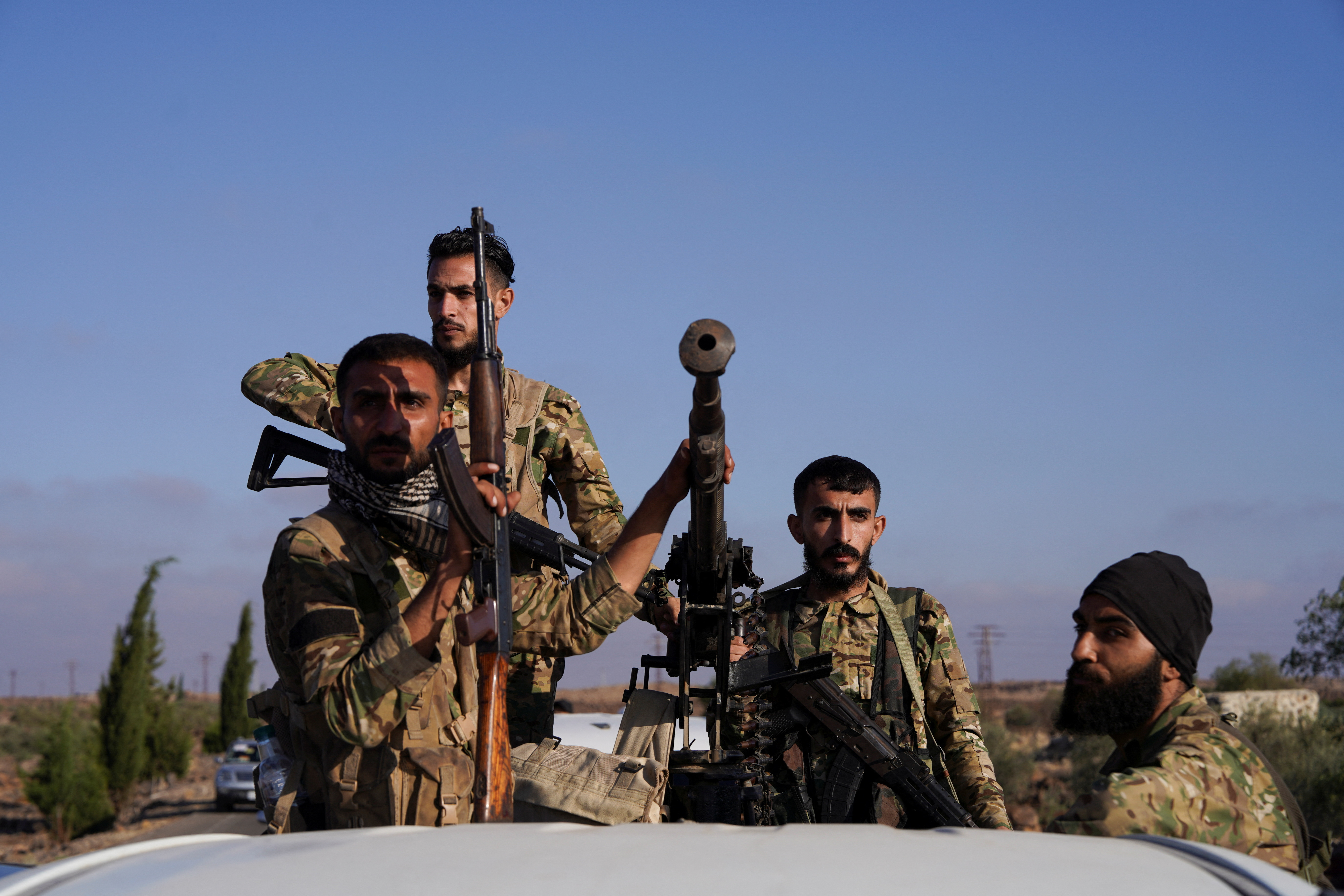 Members of Syrian security forces ride on a back of a truck after Syrian troops entered the predominantly Druze city of Sweida