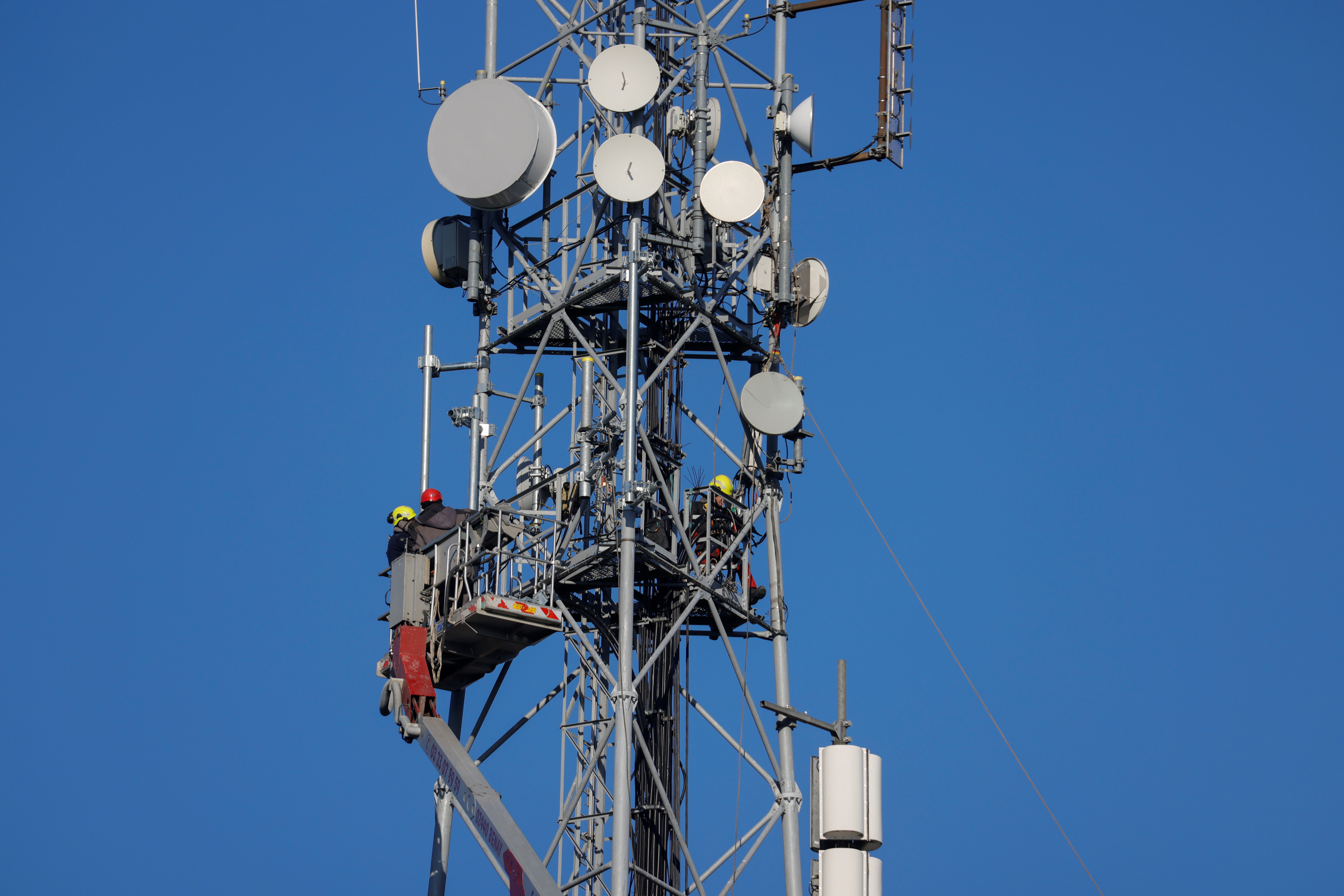 FILE PHOTO: Workers set up a mobile telecom transmitter that relays in Tilloy-lez-Cambrai