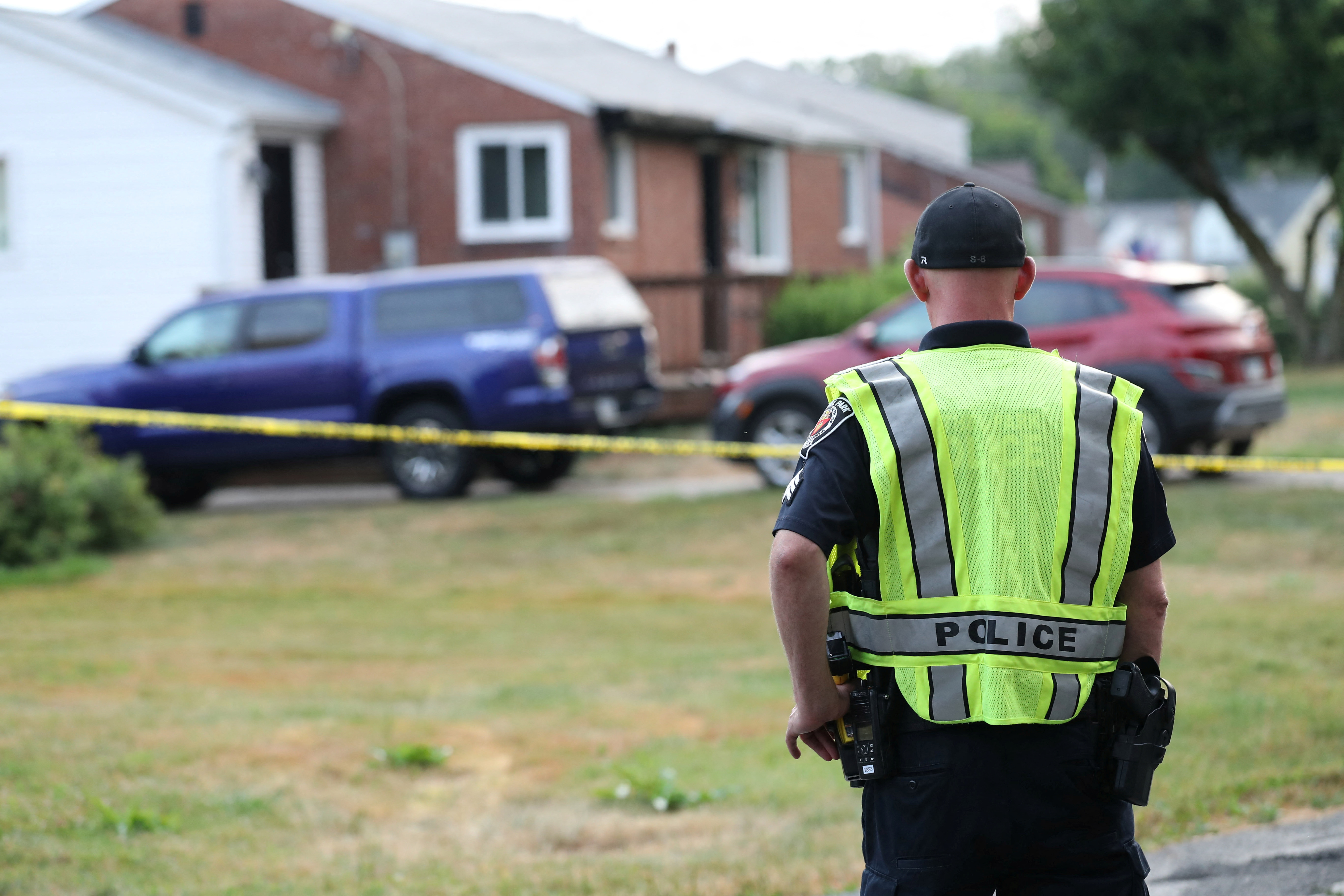 A police officer stands outside the home of Trump shooting suspect Thomas Crooks