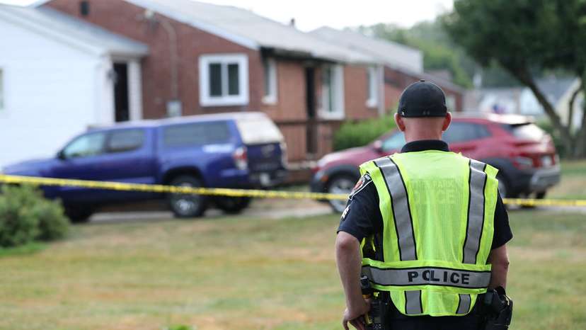 A police officer stands outside the home of Trump shooting suspect Thomas Crooks