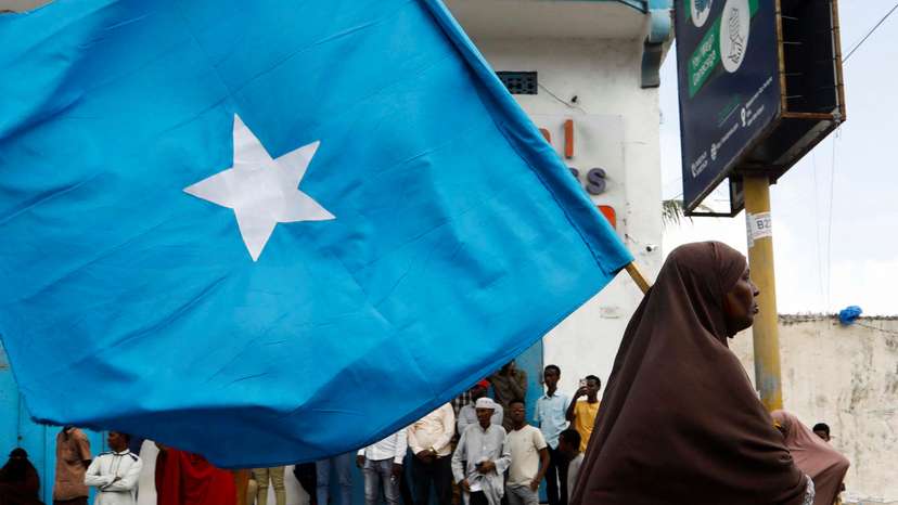 A Somali woman carries their flag during a march against the Ethiopia-Somaliland port deal along KM4 street in Mogadishu