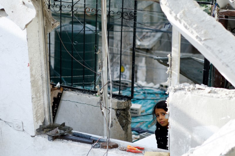 Palestinians react at the site of an Israeli strike on a house, in Rafah
