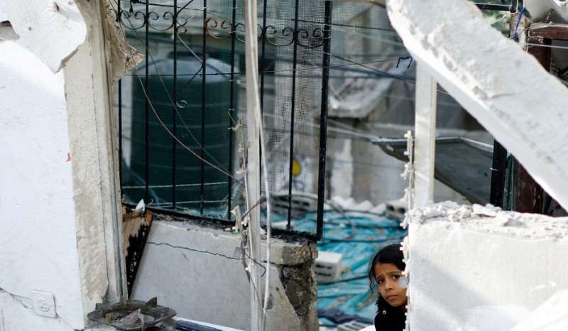 Palestinians react at the site of an Israeli strike on a house, in Rafah