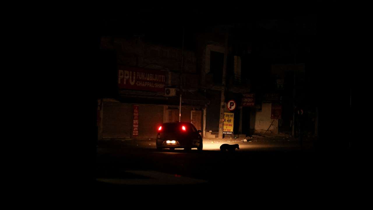 A car moves during a blackout in the city of Amritsar