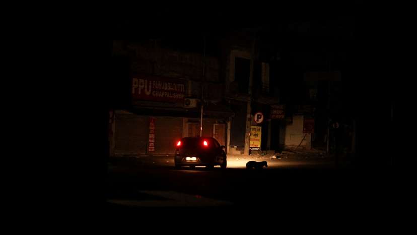 A car moves during a blackout in the city of Amritsar