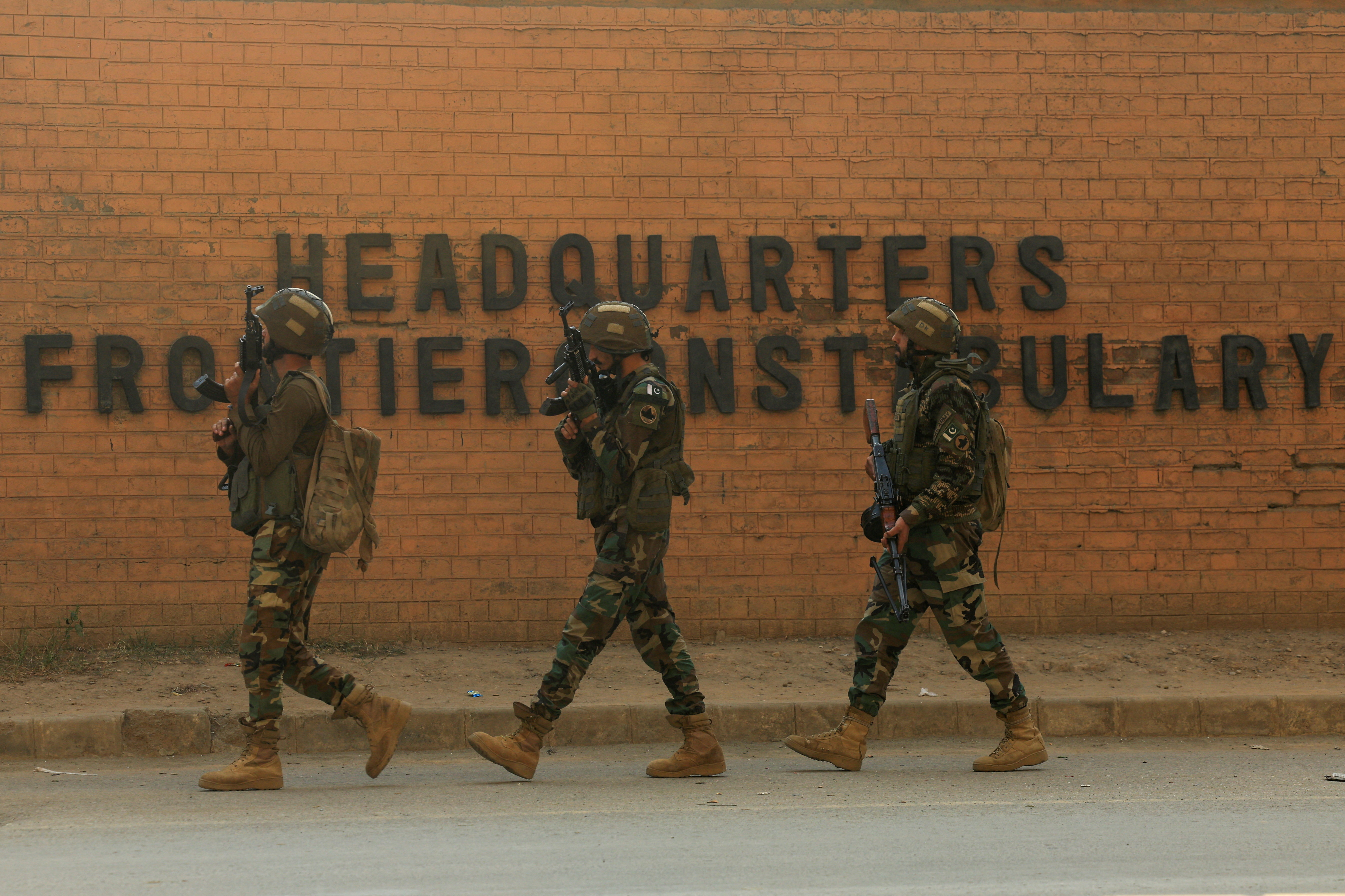Army soldiers walk, after suicide bombers targeted the headquarters of a Pakistani paramilitary force in Peshawar