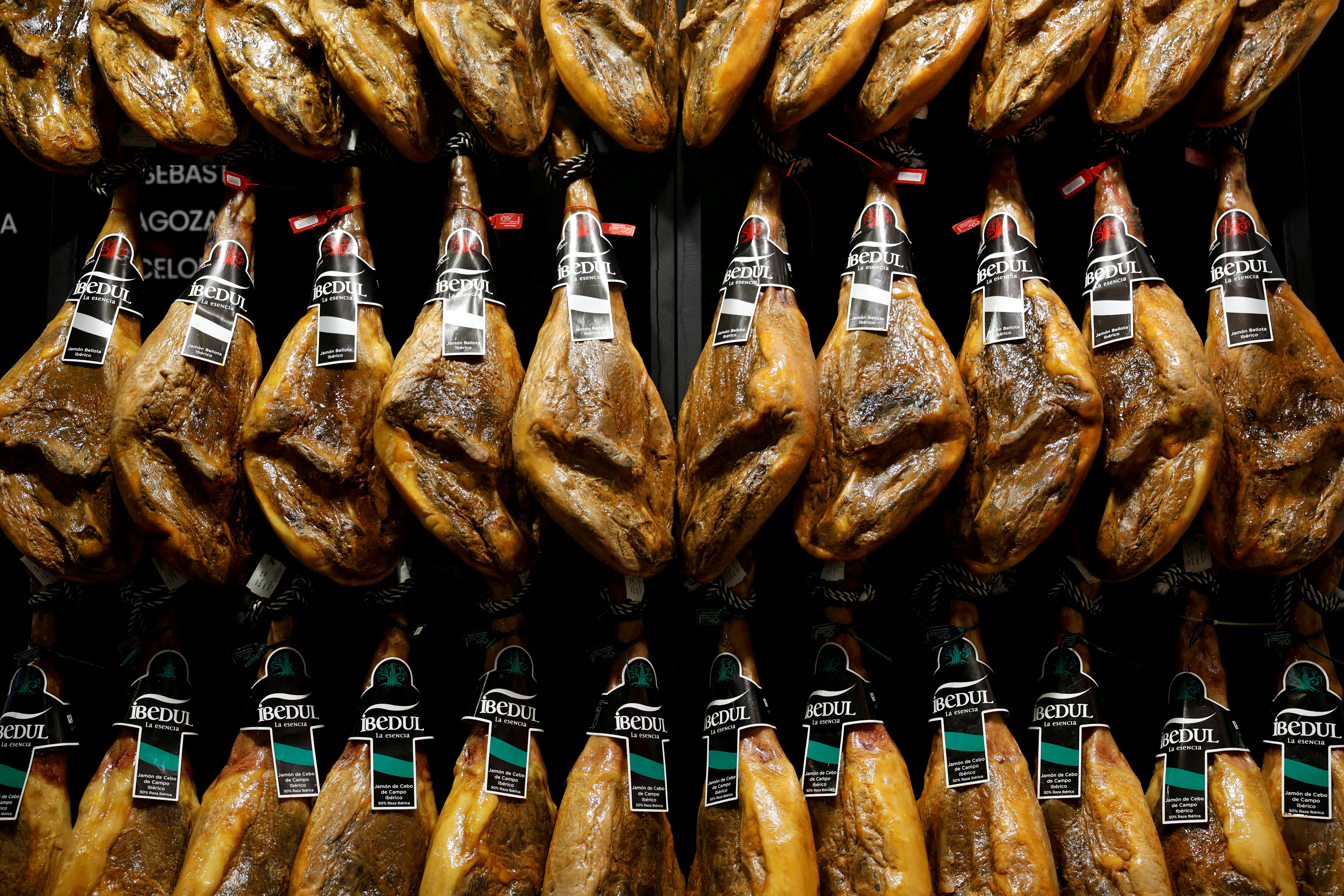 FILE PHOTO: Iberian ham legs hang at the Gourmets Fair in Madrid