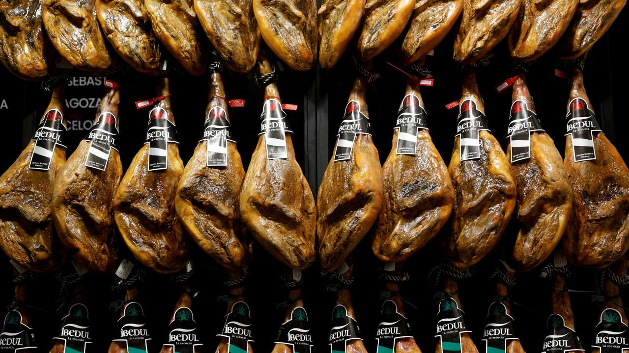 FILE PHOTO: Iberian ham legs hang at the Gourmets Fair in Madrid