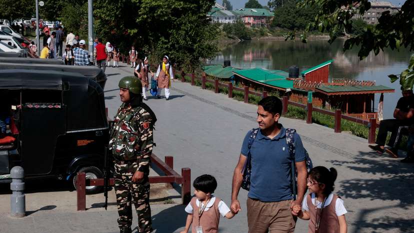 A father walks with his daughters as schools reopen after the ceasefire announcement between India and Pakistan, in Srinagar, Indian Kashmir