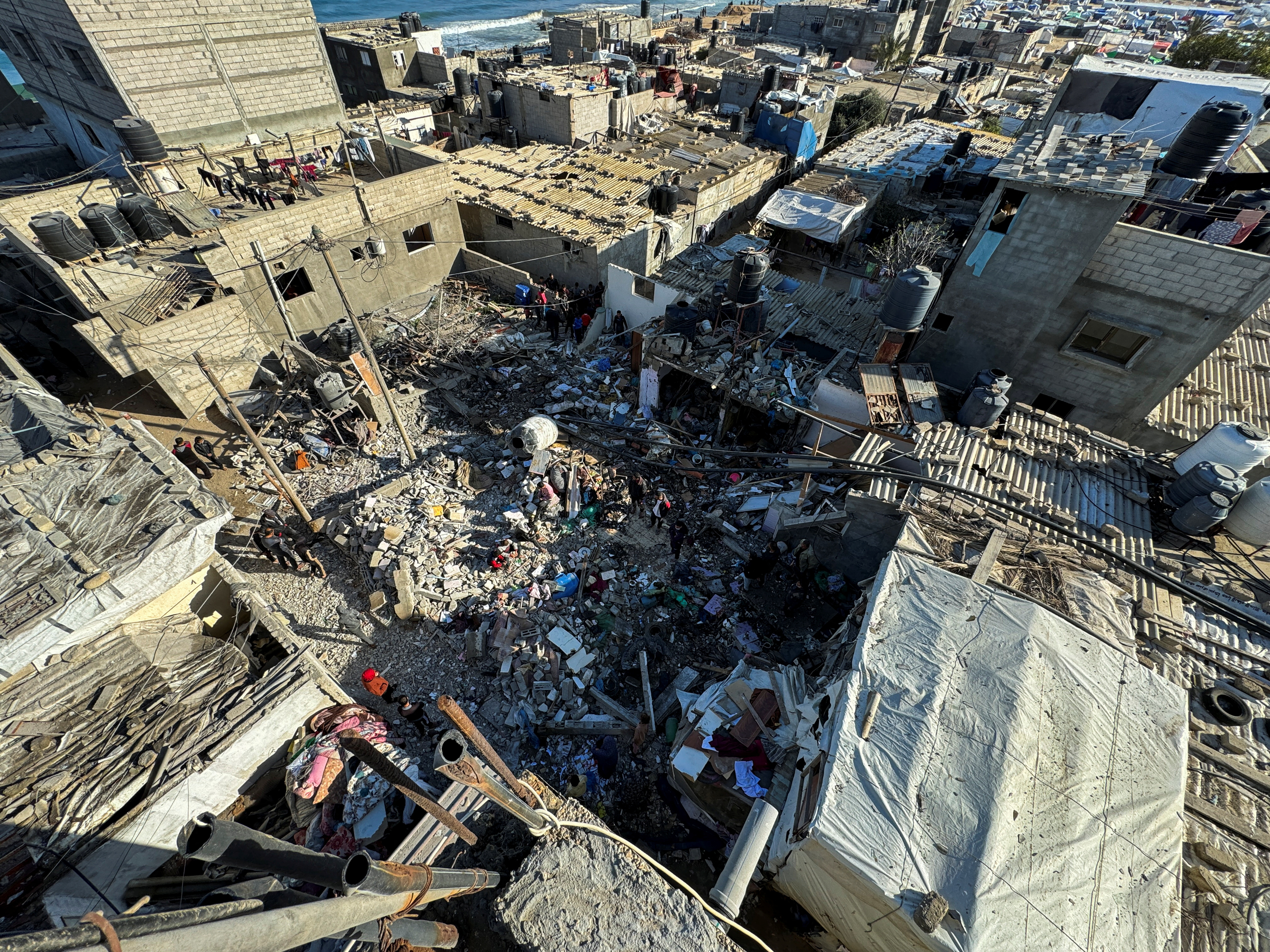 Palestinians inspect the site of an Israeli strike on a house, in Rafah