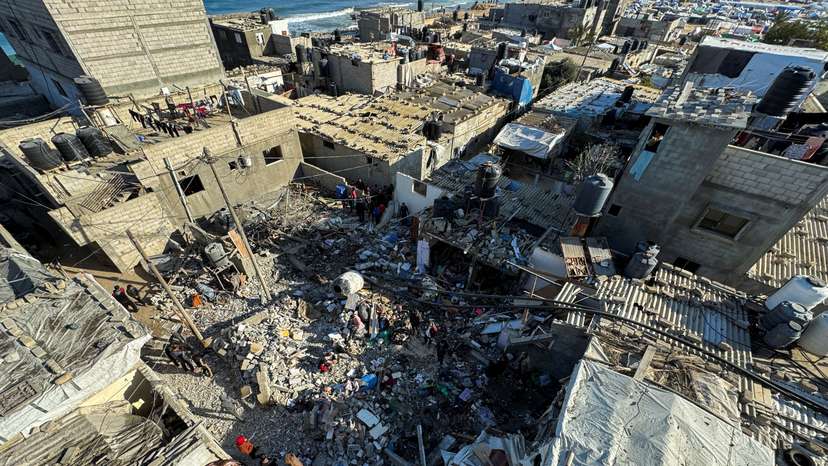 Palestinians inspect the site of an Israeli strike on a house, in Rafah