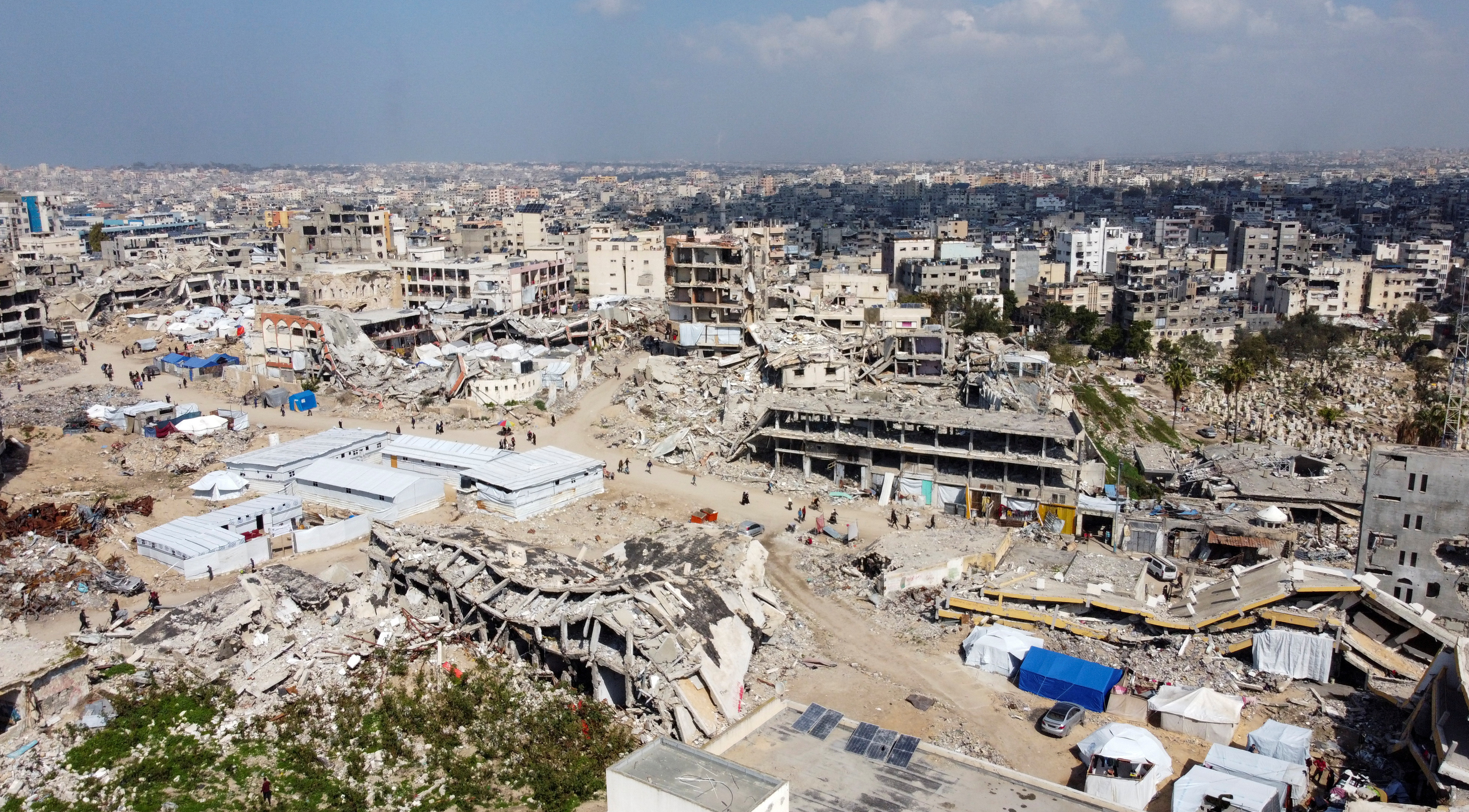 A drone view shows displaced Palestinians sheltering in tents set up near the rubble of buildings destroyed during the Israeli offensive, amid a ceasefire between Israel and Hamas, in Gaza City