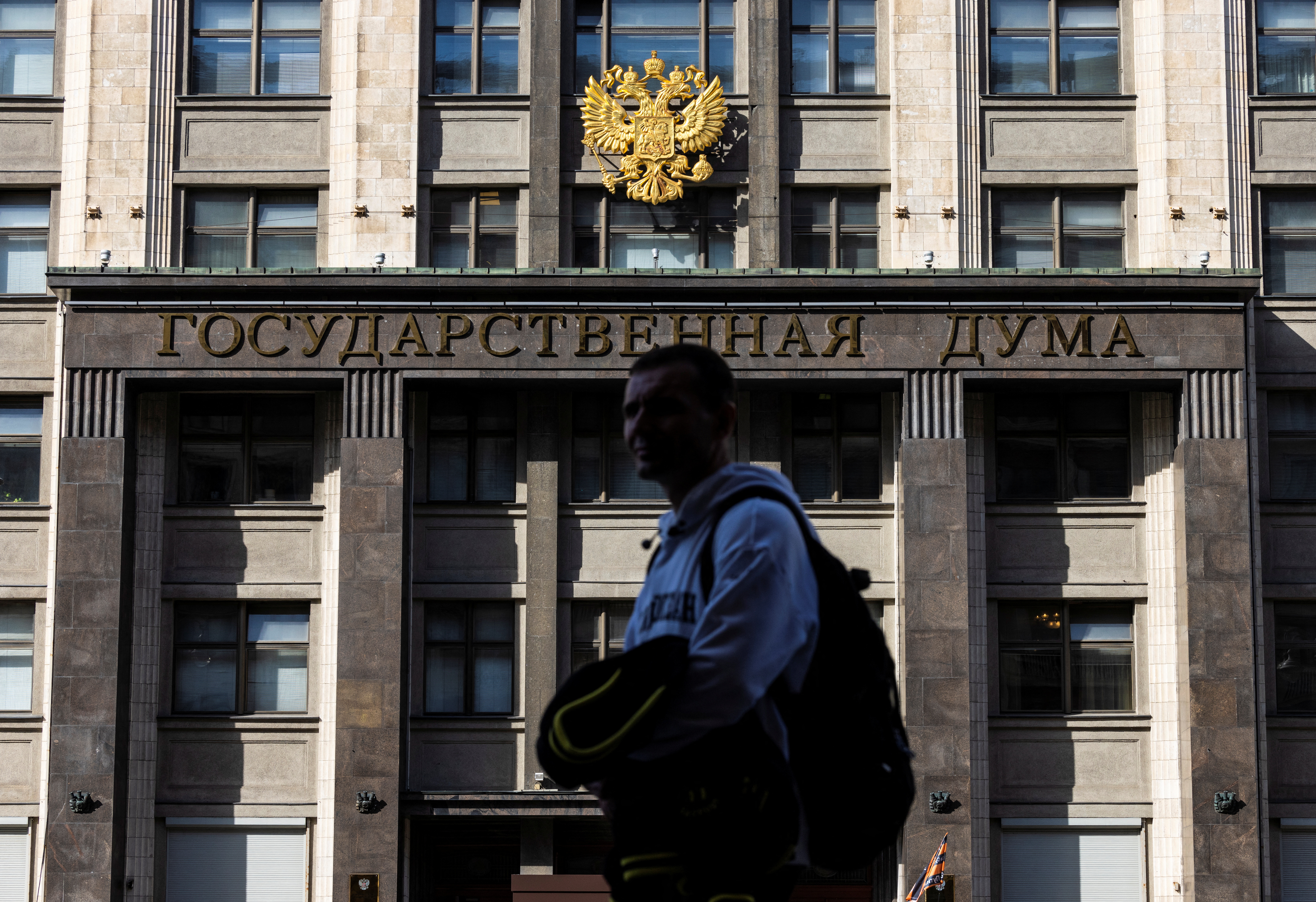 A man passes by the State Duma building, the lower chamber of Russian parliament in Moscow