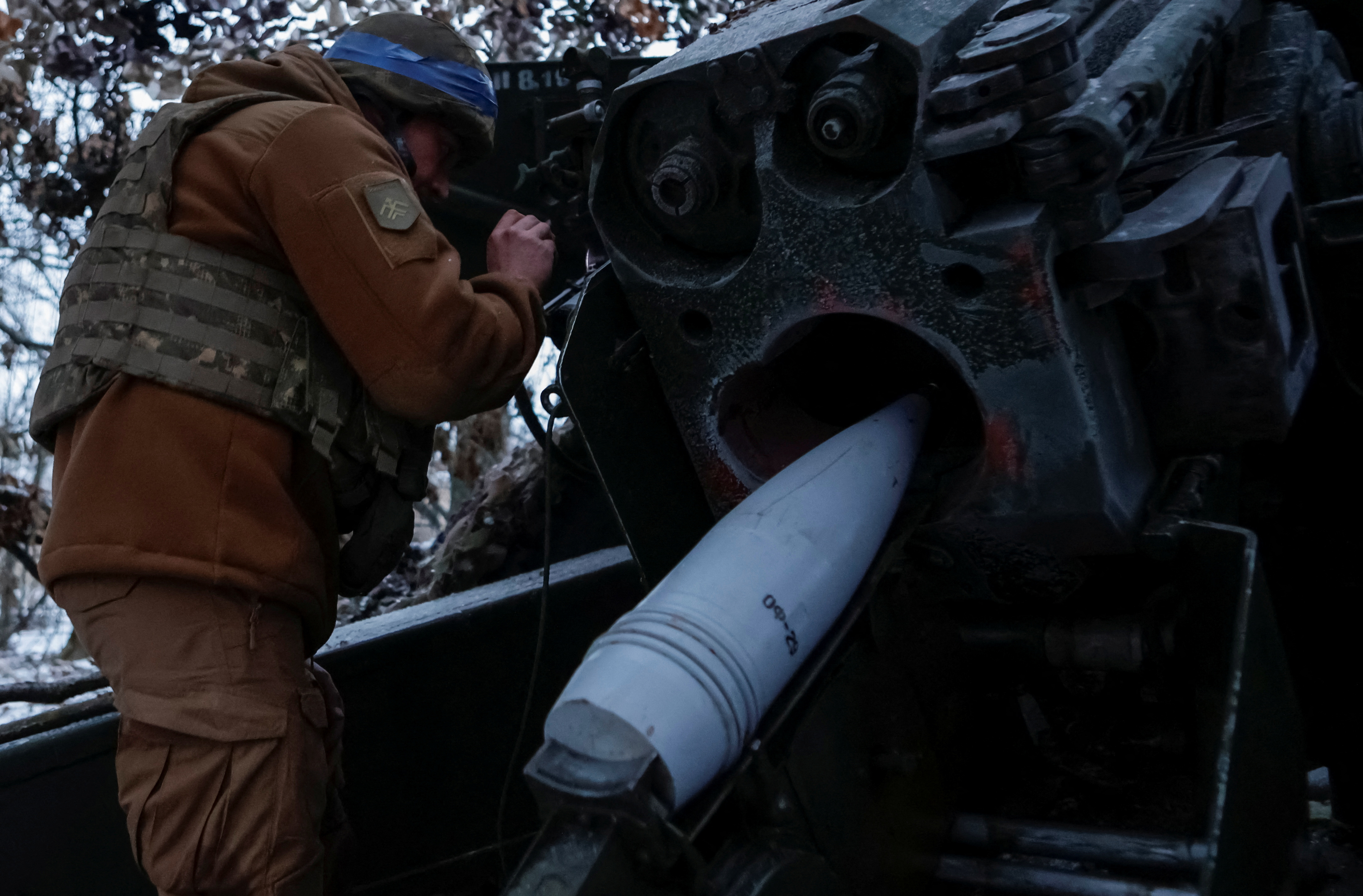 A serviceman of the National Guard of Ukraine prepares to fire a howitzer towards Russian troops at a position in a front line in Kharkiv region