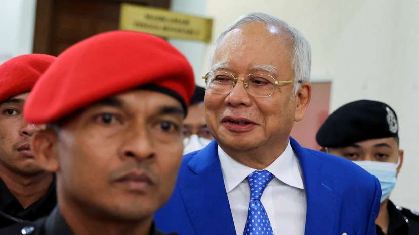 Former Malaysian Prime Minister Najib Razak is escorted by prison officers as the jailed politician leaves the court after court proceedings in Kuala Lumpur
