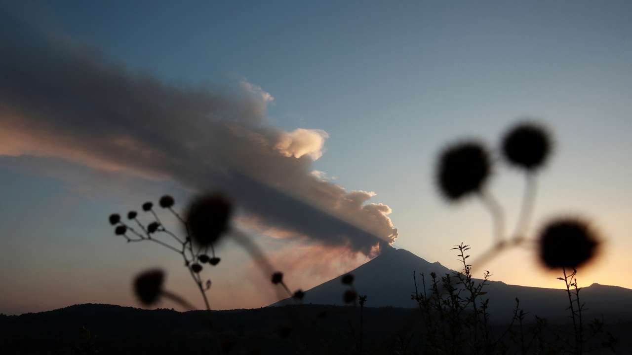 Popocatepetl volcano spews a column of ash and smoke, as seen from Santiago Xalitzintla